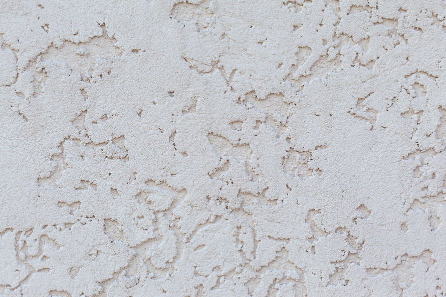 Close-up dinding putih dengan tekstur stucco dekoratif