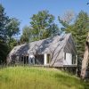 Eksterior rumah kayu DogTrot Magnetawan di tengah pepohonan