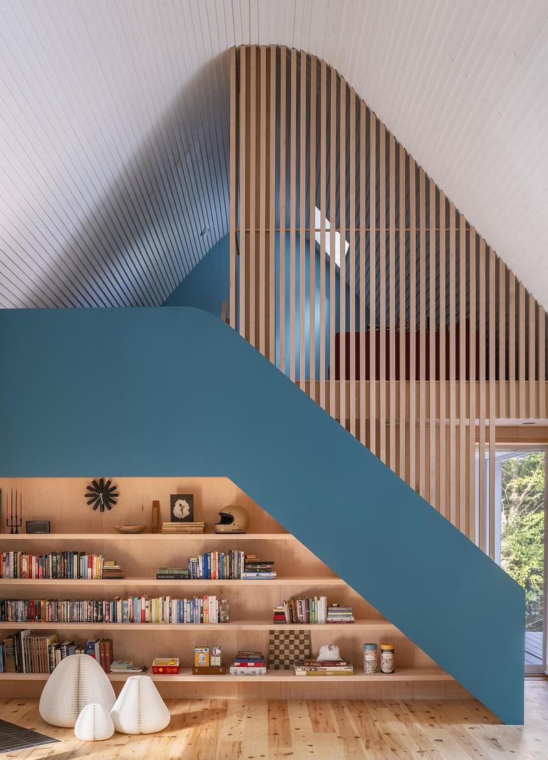 Interior dengan dinding biru, rak terbuka dan tangga menuju loteng