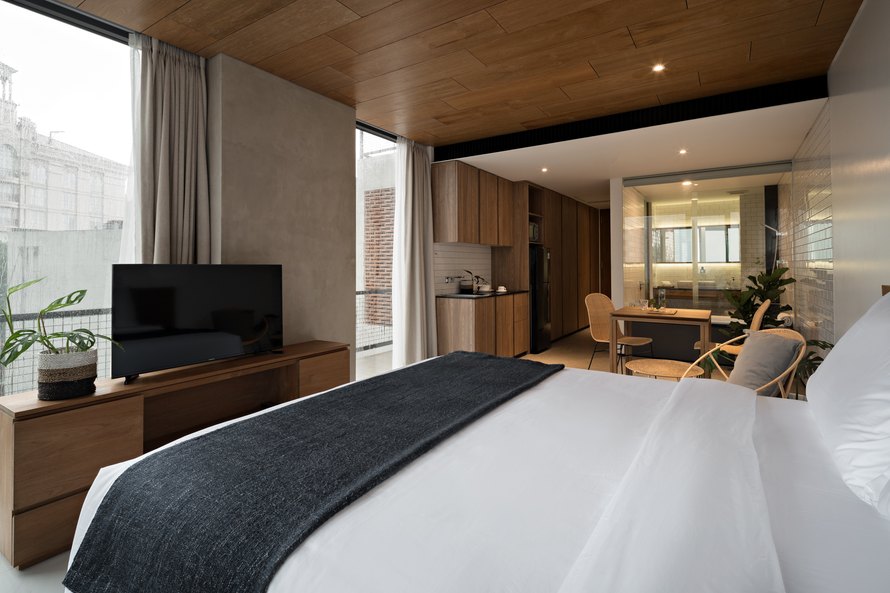 Ruang tidur Nagomi Suites dengan area duduk di dekat taman